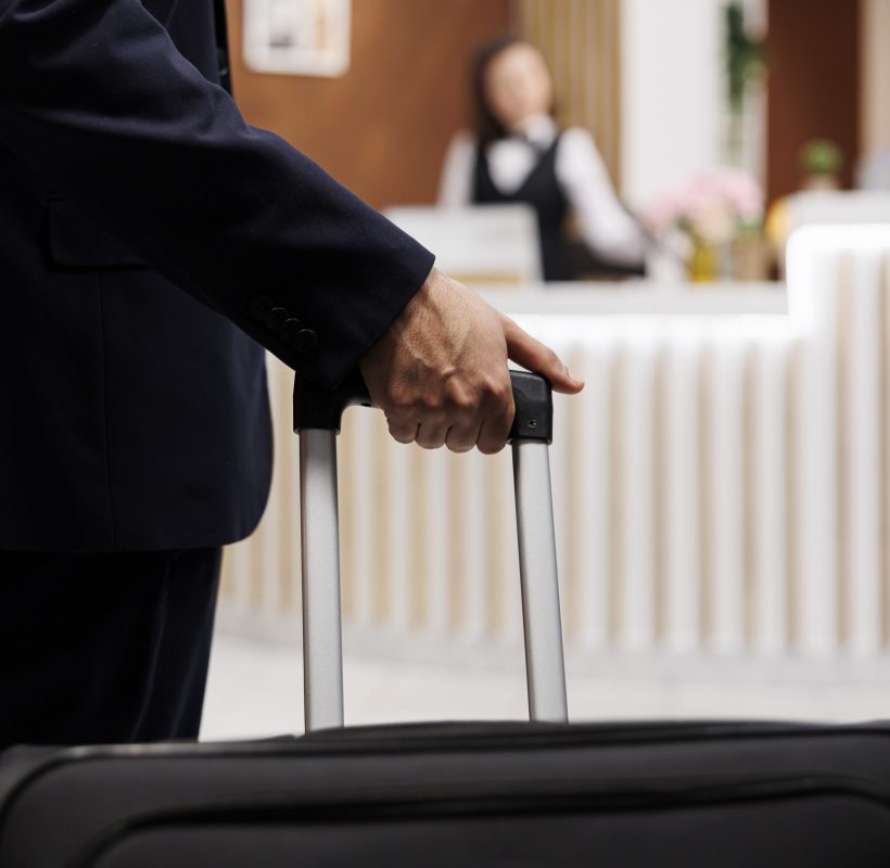 hotel-guest-entering-reception-with-luggage-travelling-abroad-attend-important-business-meetings-entrepreneur-approaching-front-desk-check-booking-accommodation-close-up-scaled.jpg